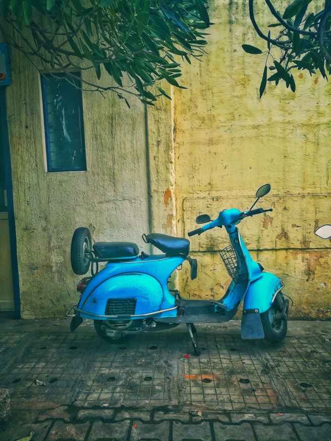 teal motor scooter on the street